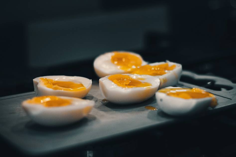 Modern egg boiler on kitchen counter with fresh eggs